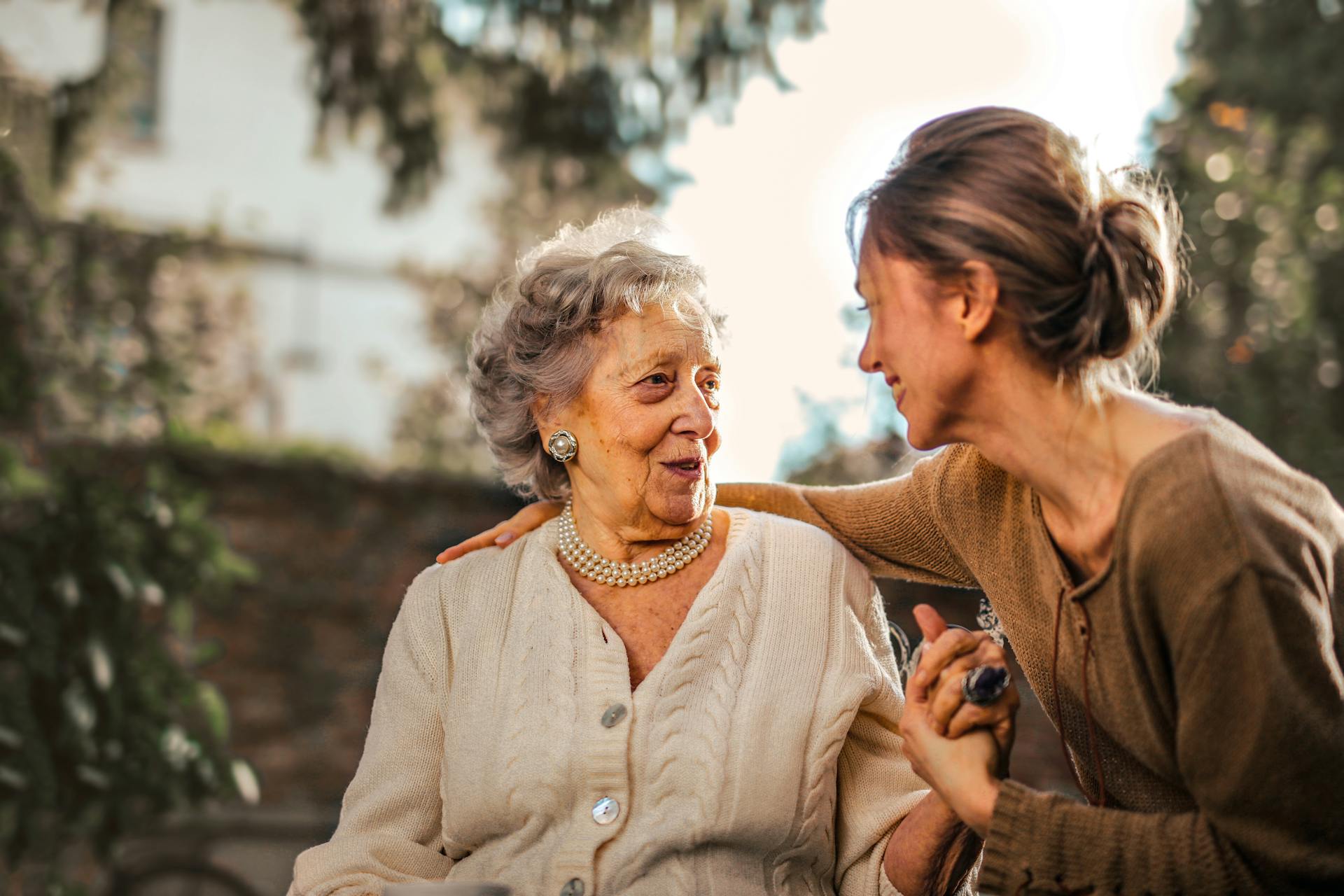 Mother and daughter discuss retirement options outside in the backyard of their house