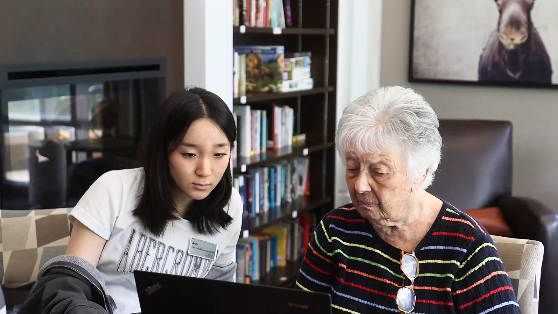 Staff member helping resident use the computer at retirement home